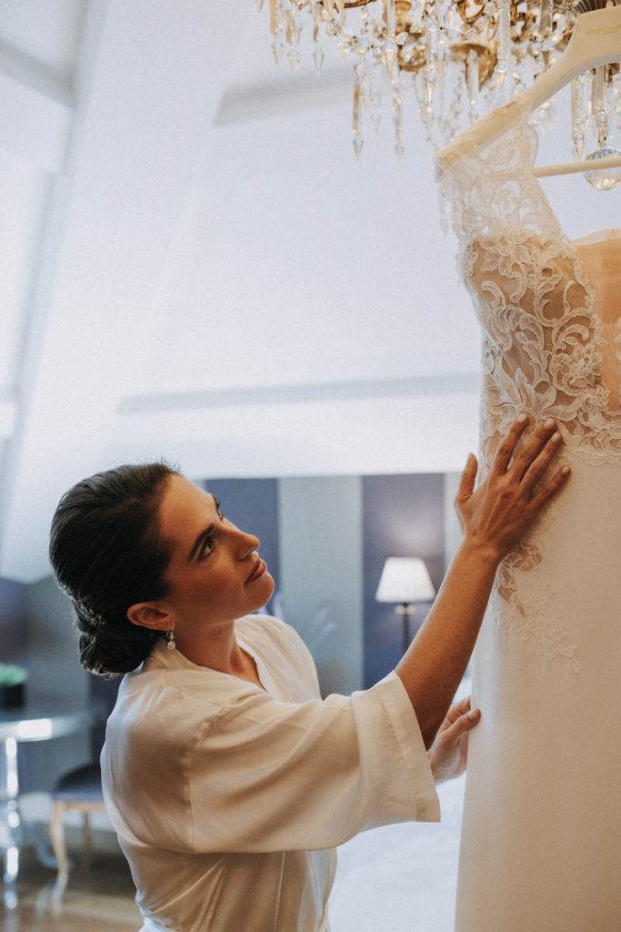 foto de una novia preparando su vestido colgado en alto en una suite en una boda en a A Quinta da Auga